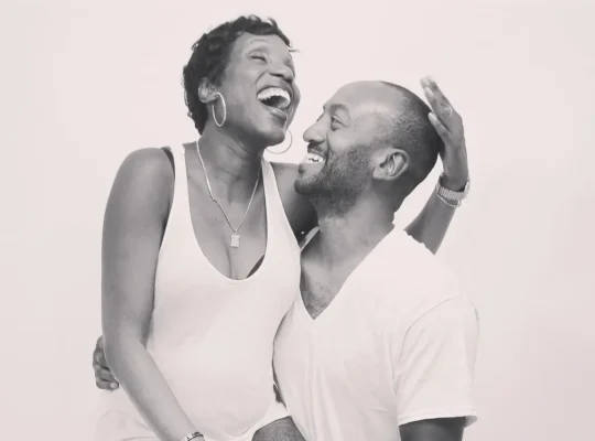Pareja feliz riendo y compartiendo un momento de bienestar y vitalidad, reflejo de la conexión entre salud y belleza.
